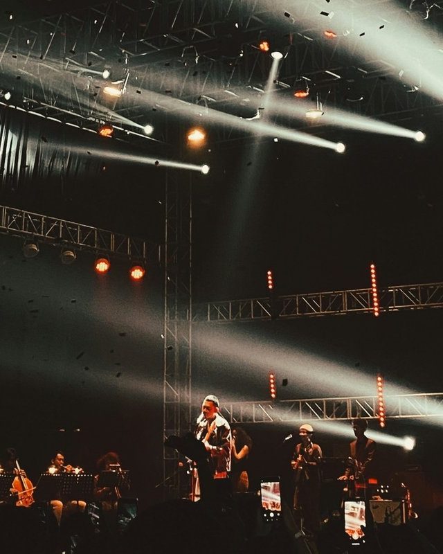 A band on stage under spotlights